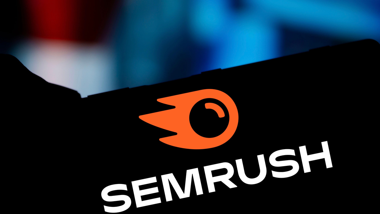 Silhouette of the Semrush logo being displayed on smartphone held in someone’s hand